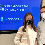 Christen and Kristian standing by TV with SOSORT Meeting Logo