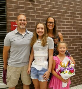 family with girl wearing scoliosis brace